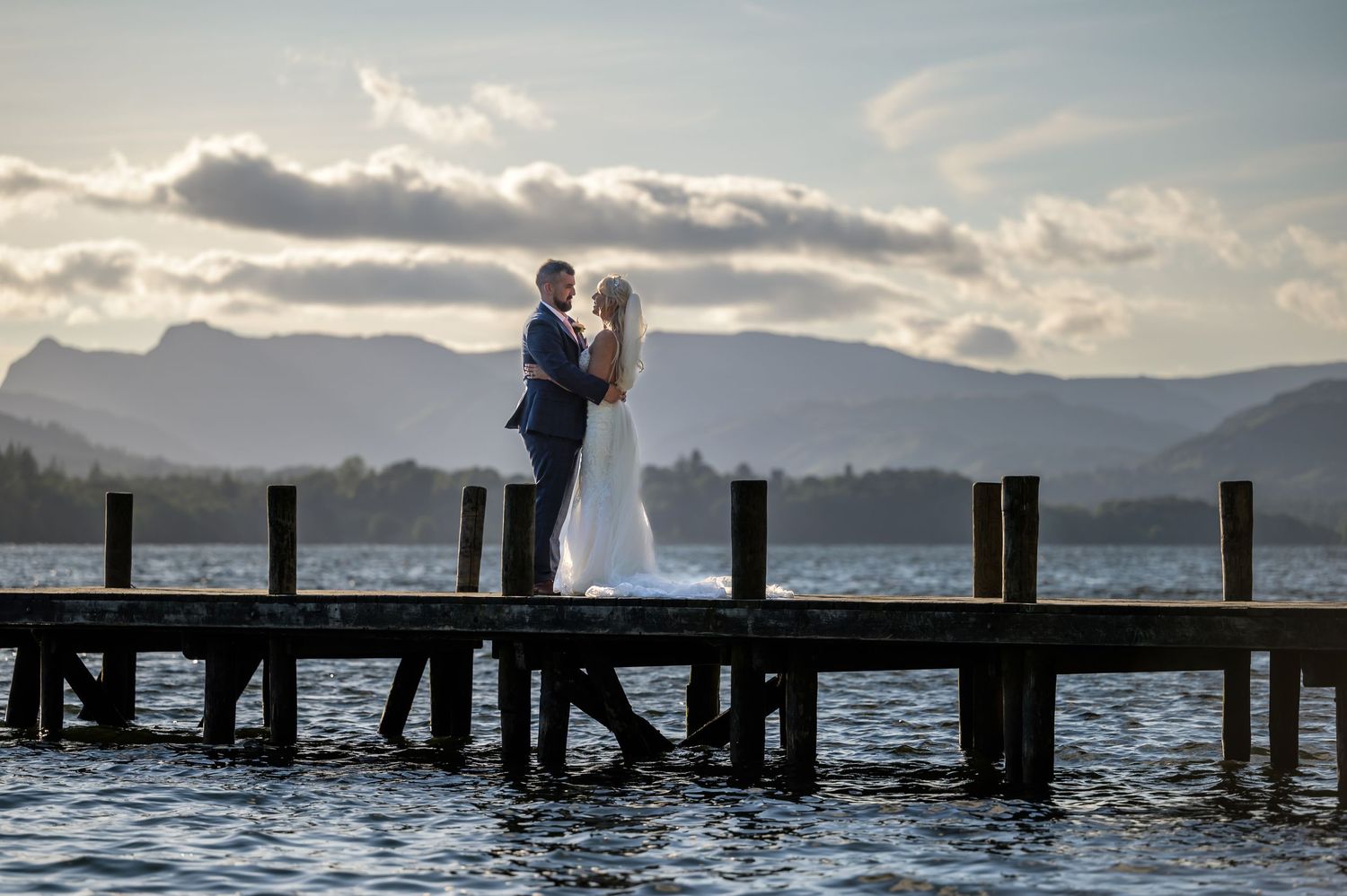 Bride and groom on Windermere jetty at sunset