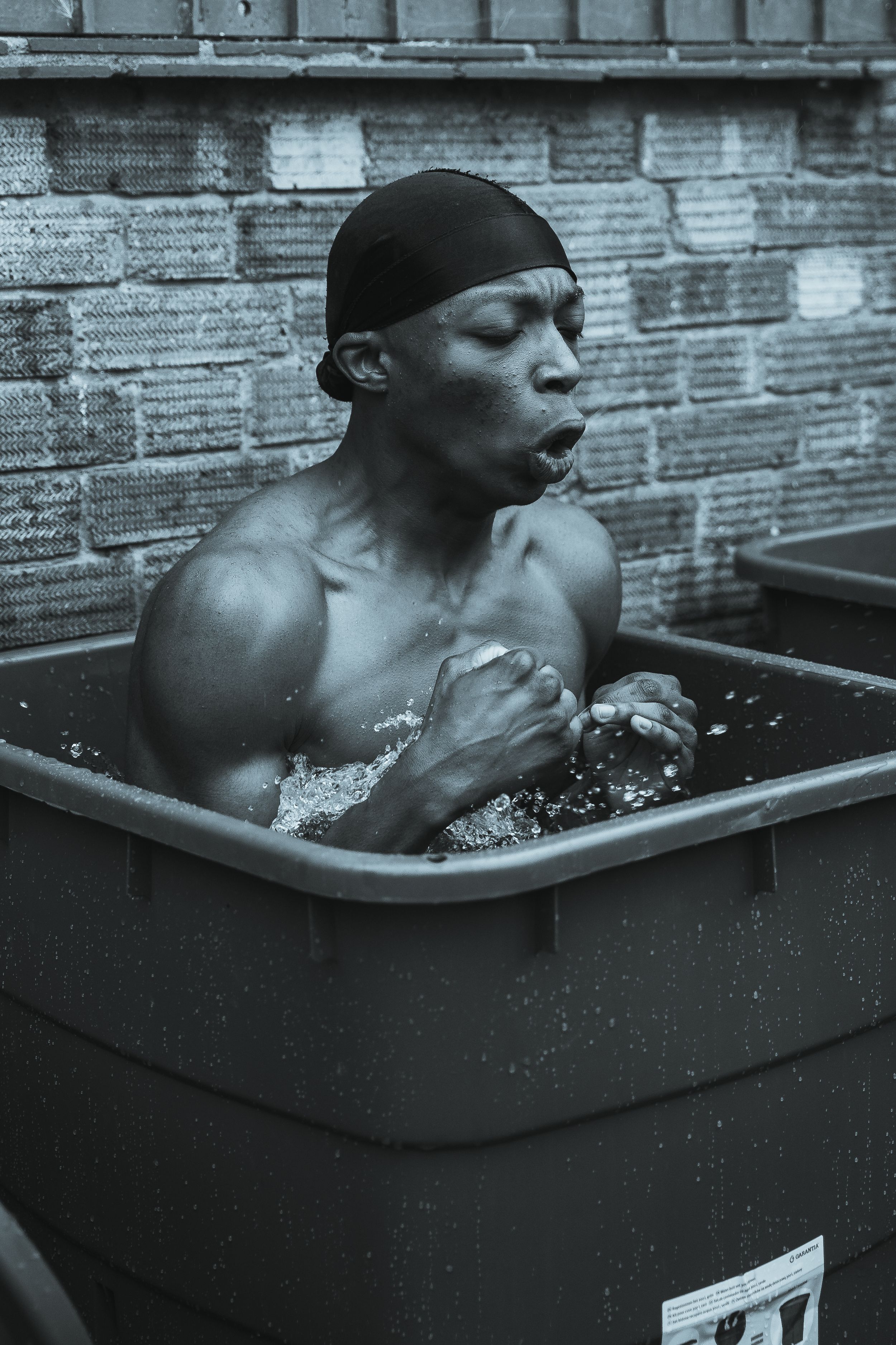 Black and white photo of athlete in ice bath recovery session.