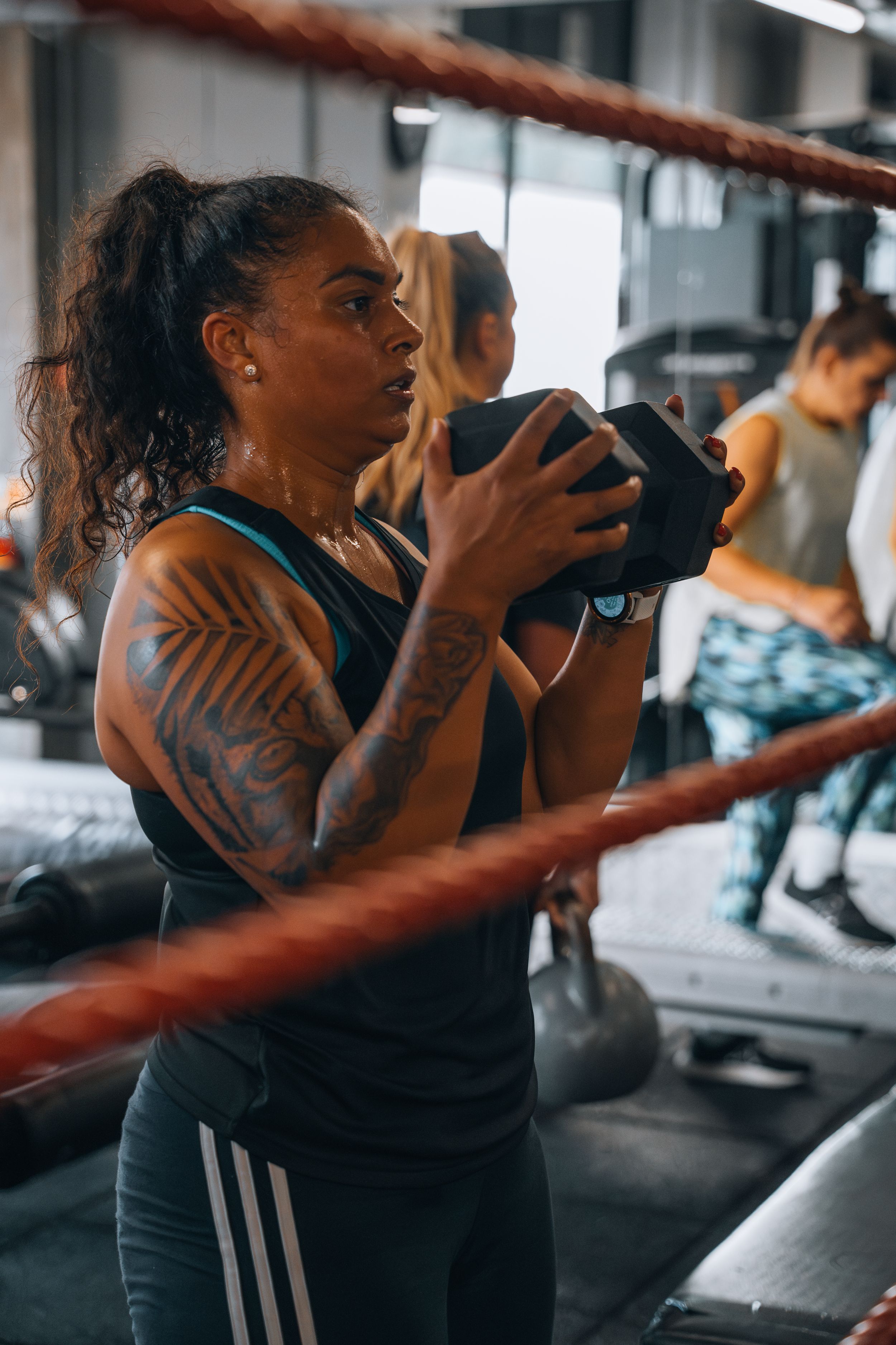 Athletes practicing with medicine balls against a mirrored wall in a fitness facility.