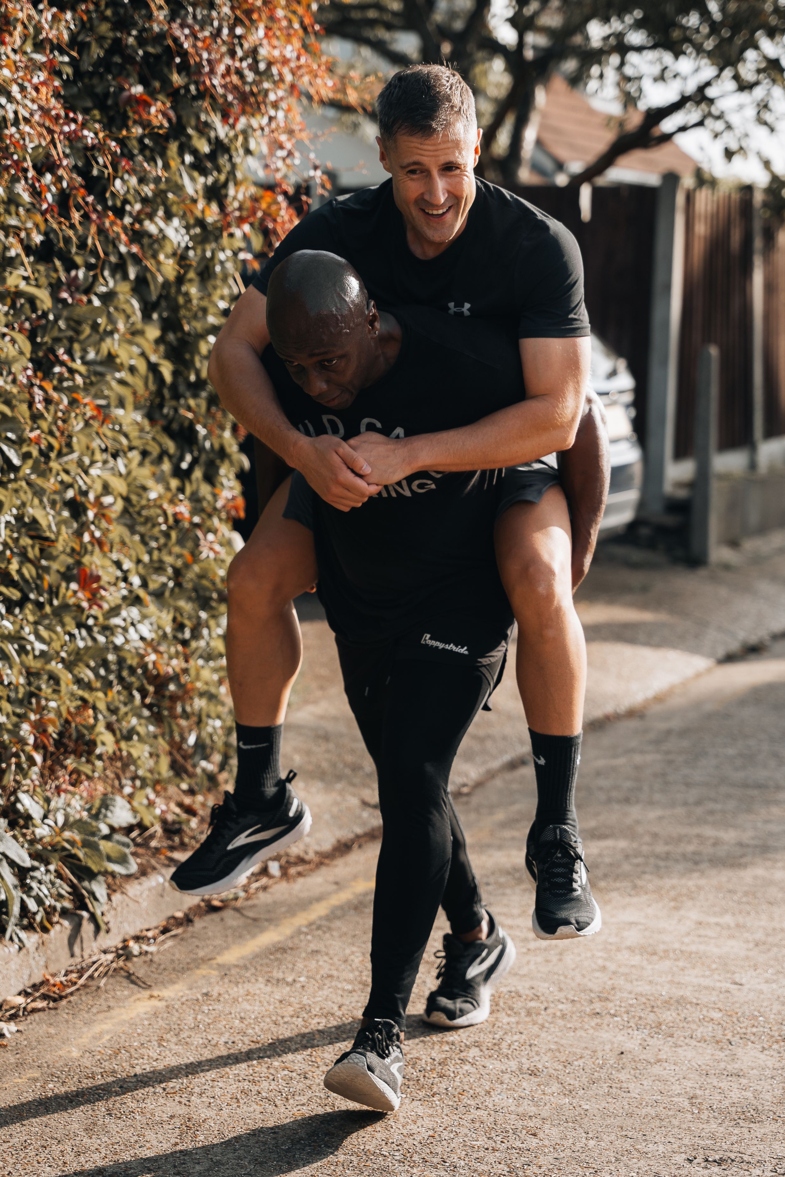 Athletes performing partner exercises on an outdoor path during training.