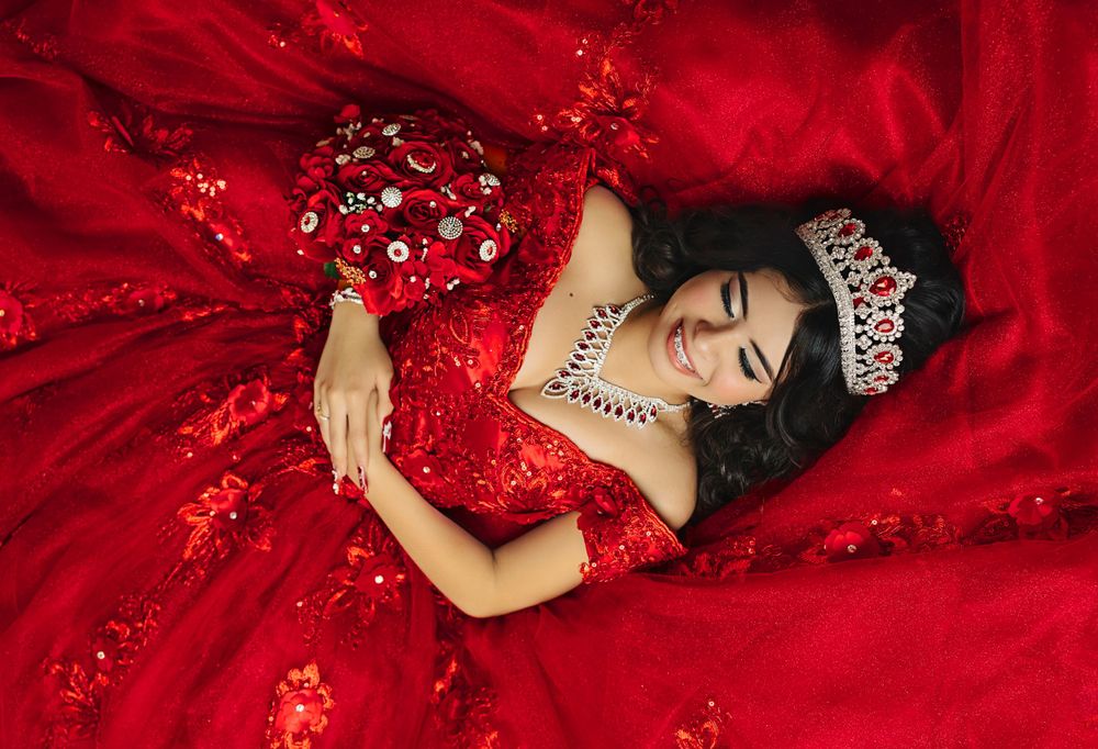 Overhead view of red ball gown with crystal embellishments and matching bouquet.