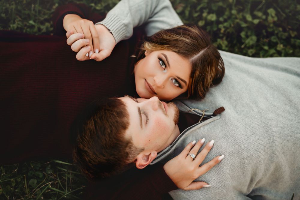 Intimate lifestyle couple cuddling in gray sweaters during photo session.
