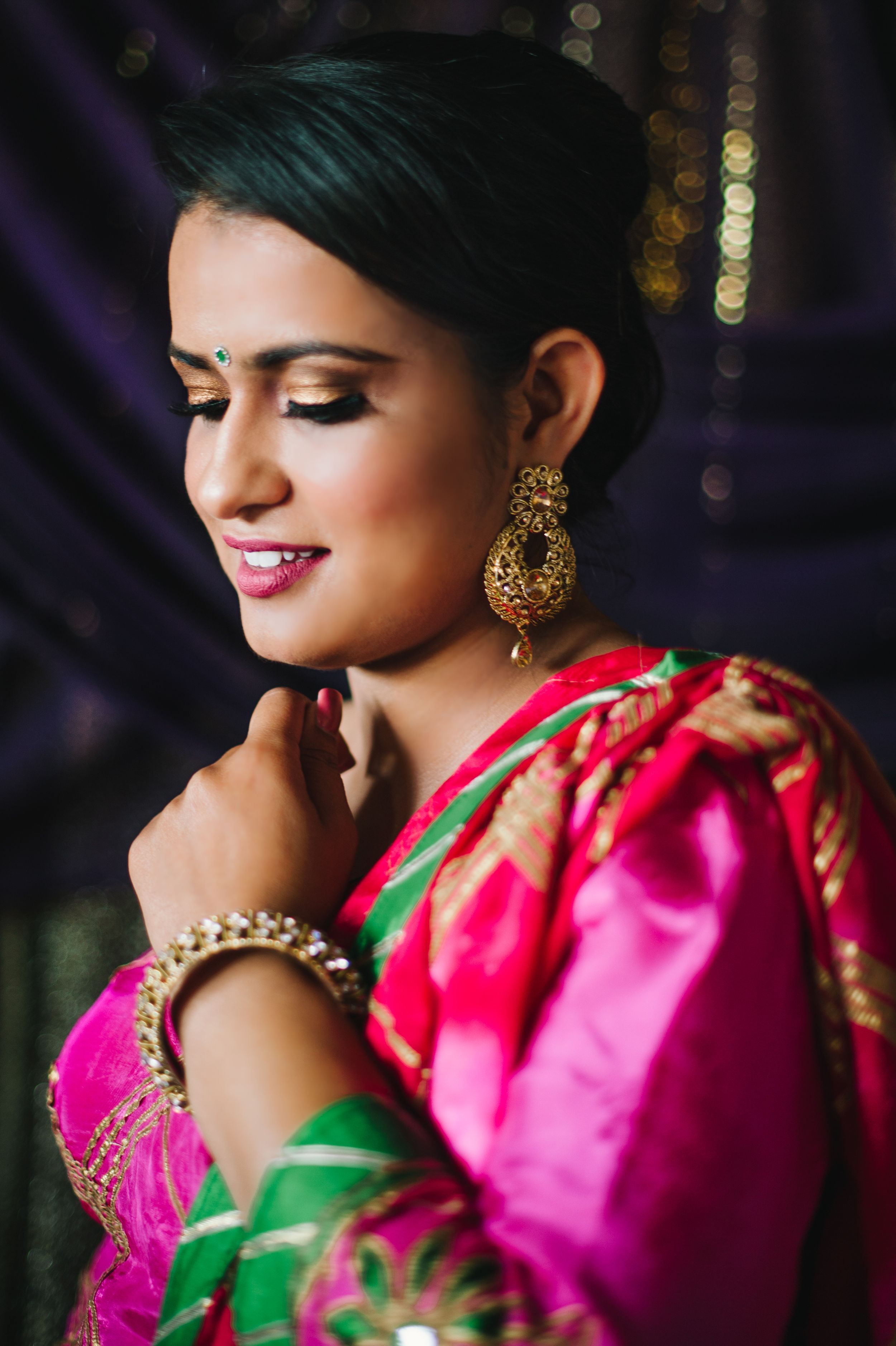 Traditional Indian attire with gold jewelry and makeup in an artistic portrait style.