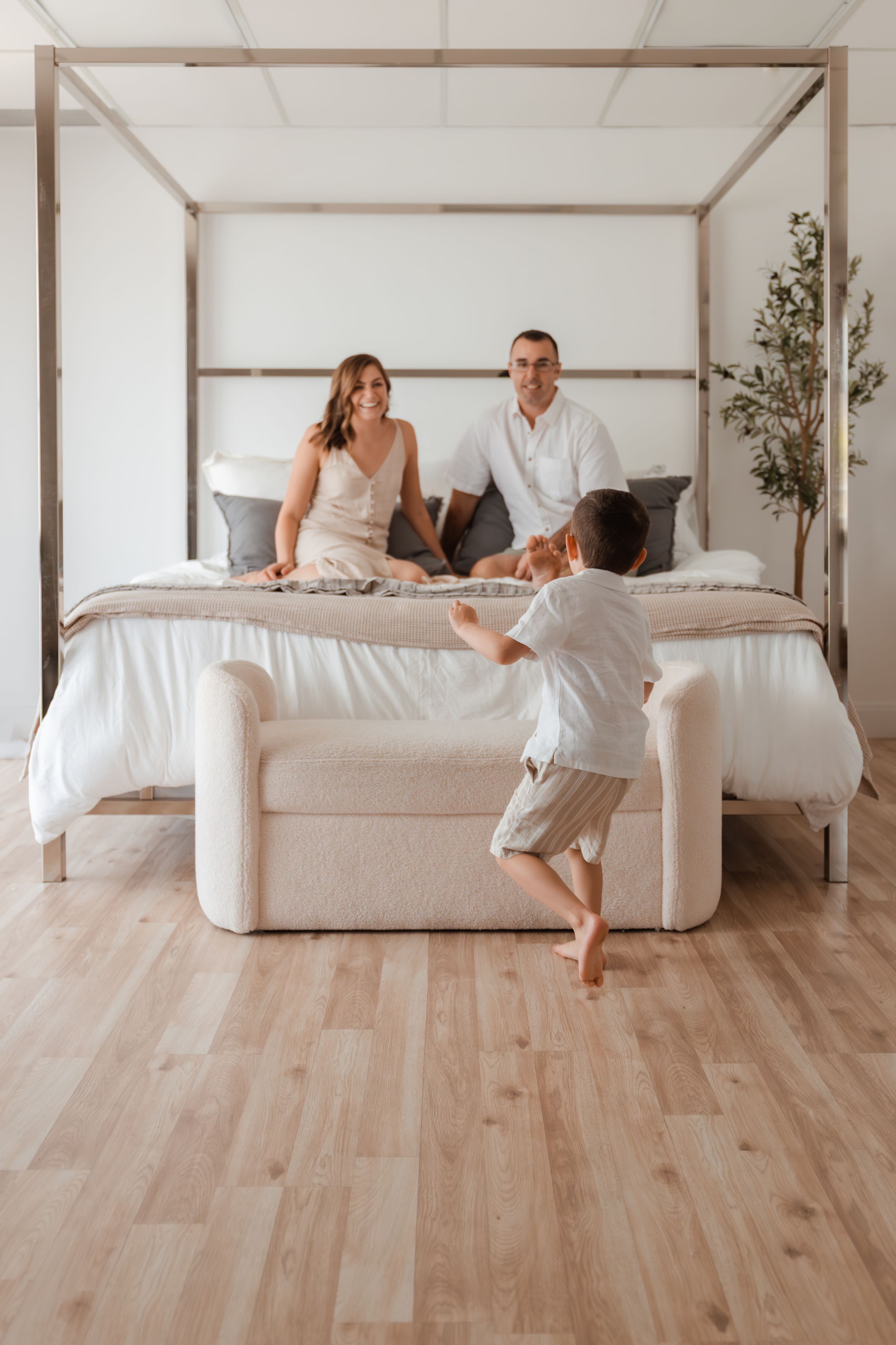 Modern bedroom scene with canopy bed and playful family moment.