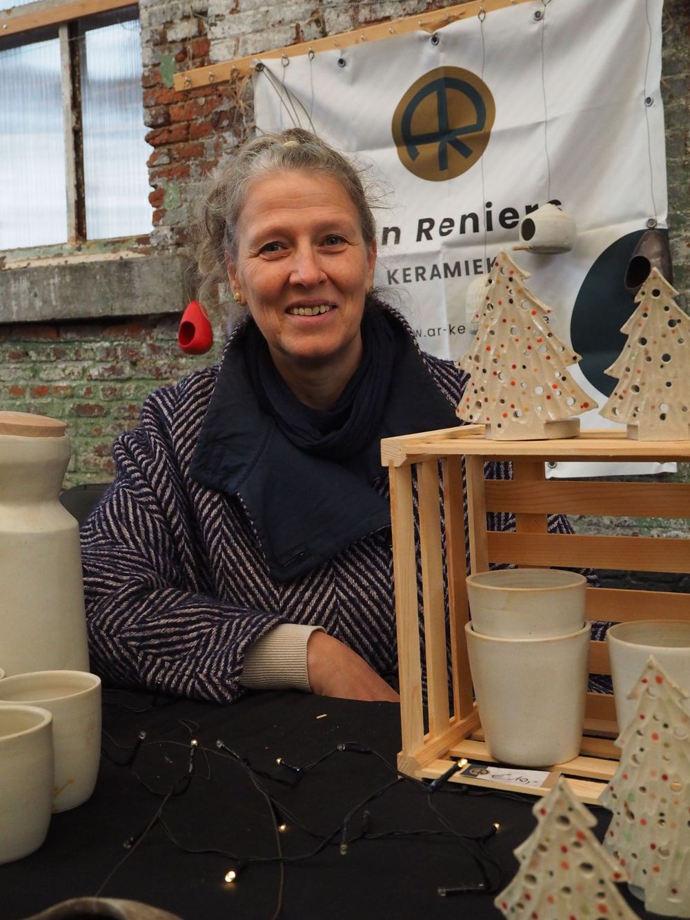 Portrait of a saleswoman in her market stall selling ceramics