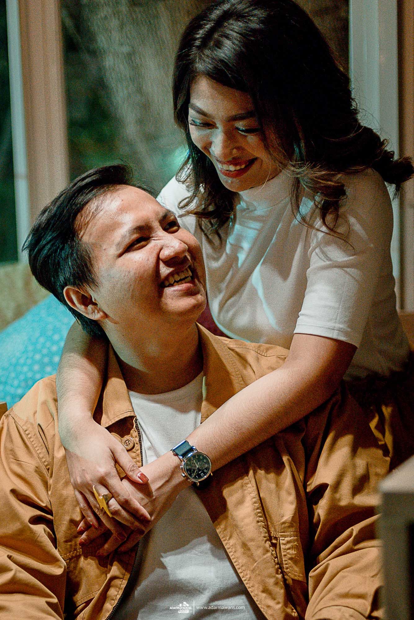 A joyful candid moment shared between a couple in casual attire.