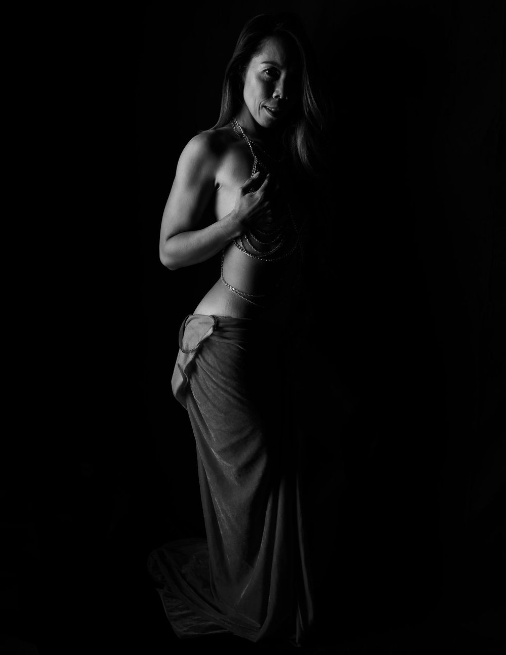 Artistic black and white portrait showing dramatic shadows and fabric draping.