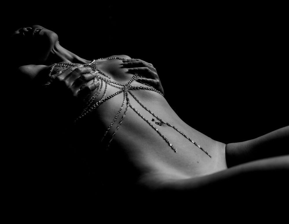Close-up of decorative body jewelry chains in black and white.