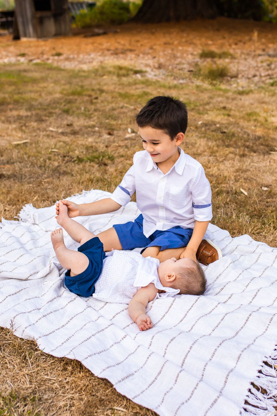 Brother tickling baby sister's toes