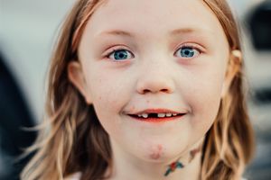 Close up portrait showing bright blue eyes and genuine smile.
