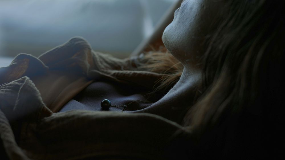 Soft focus artistic photograph of dim light and fabric textures in muted tones.