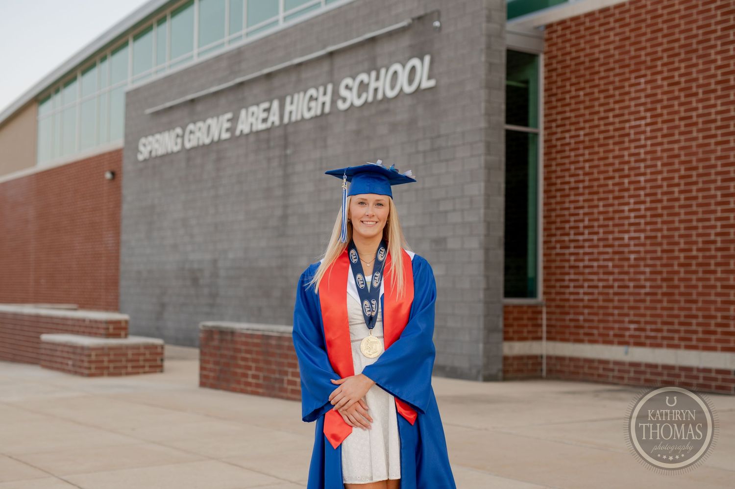 Graduate in traditional blue cap and gown poses at Spring Grove Area High School.