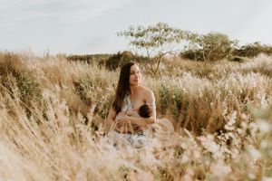 A dreamy outdoor photoshoot in a field of tall grass during sunset.