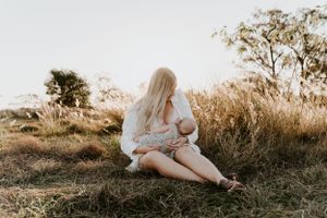 A serene moment captured in a field during golden hour with flowing white dress.