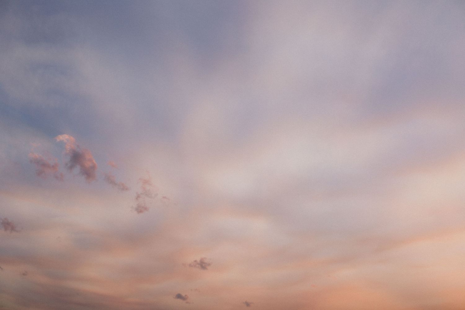Dramatic purple and pink sunset sky with wispy clouds at dusk.