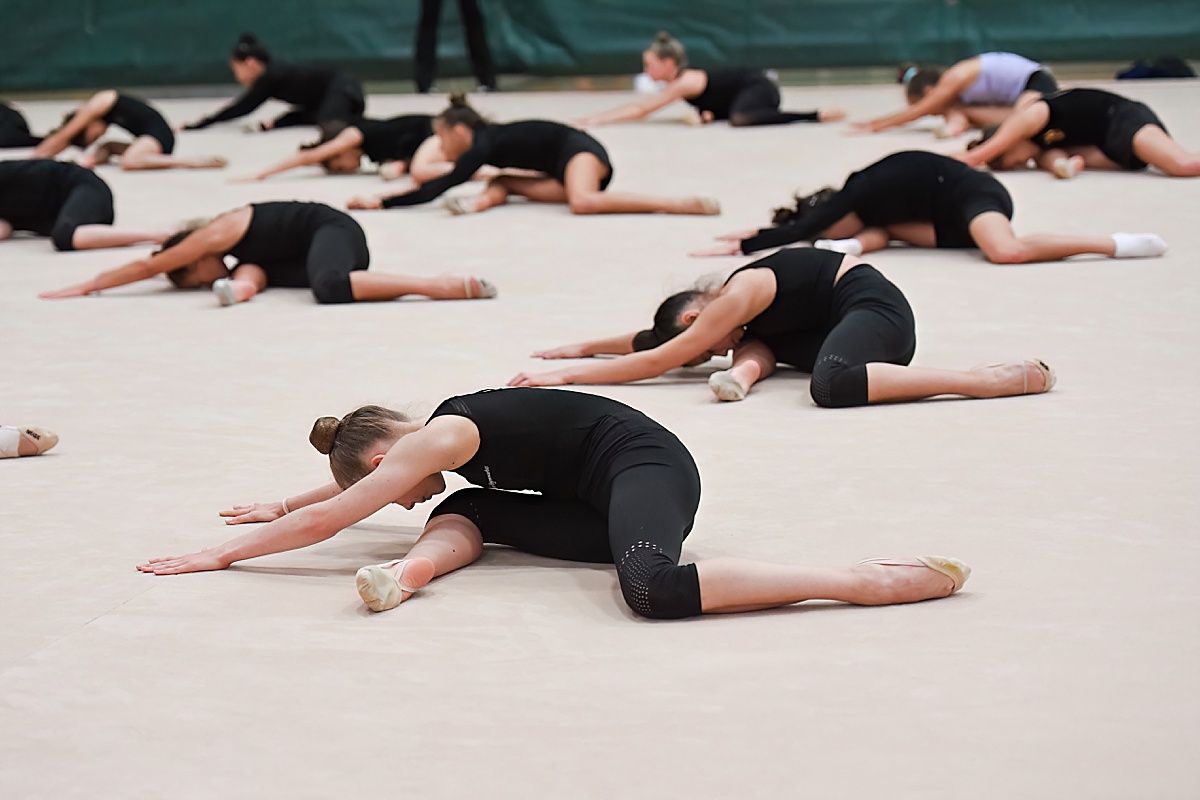 Rhythmic gymnasts stretching at camp