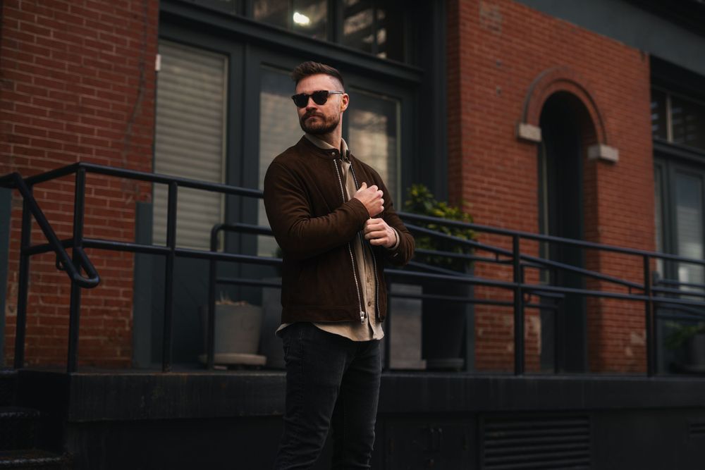 Person walking past red brick building facade in casual attire.