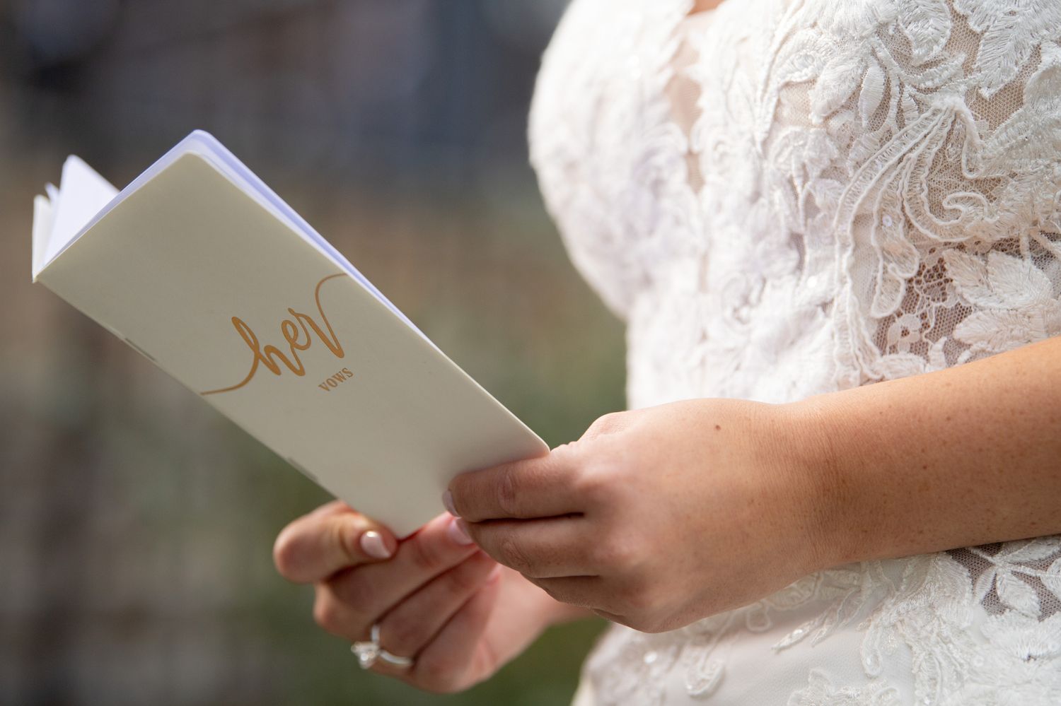 Close-up details of lace wedding dress and paper items during preparation.