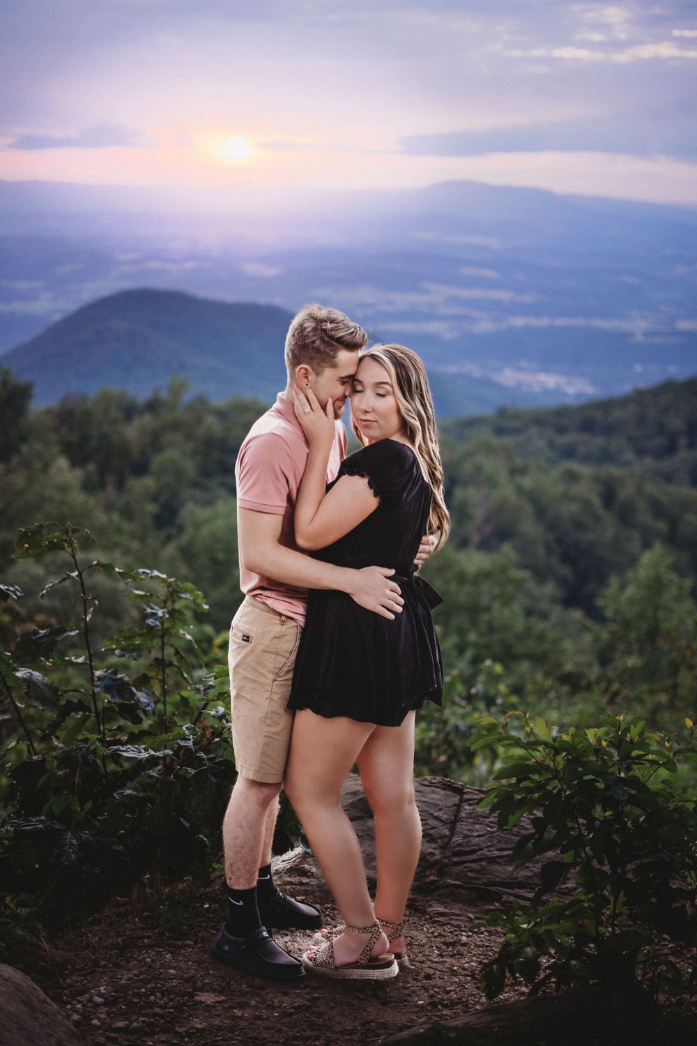 Romantic proposal moment captured on mountain overlook with sweeping valley views.