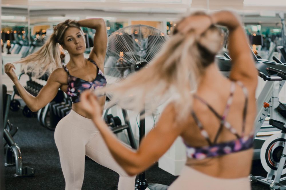 Blurred fitness photoshoot showing multiple workout poses in gym setting.