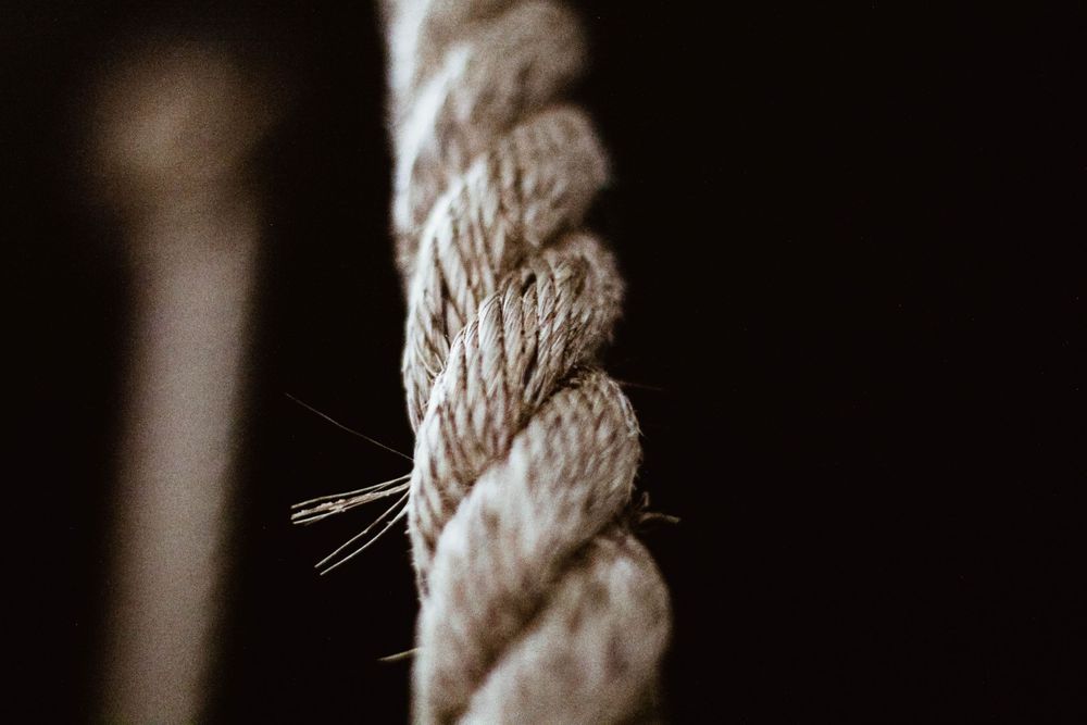 Close-up macro shot of a twisted beige rope showing detailed texture and fibers.