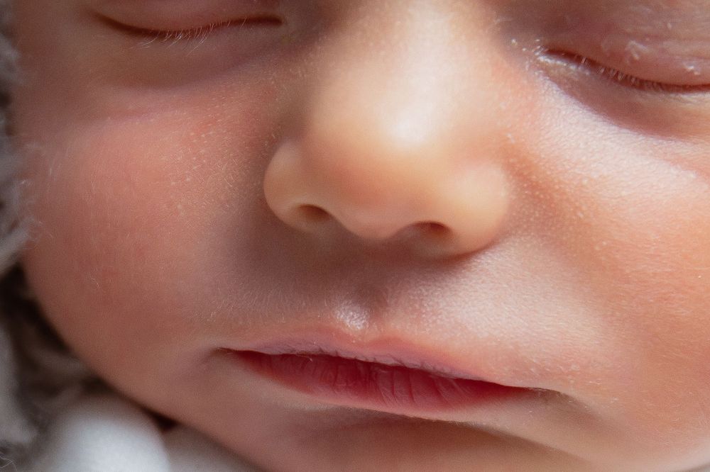 Extreme close up macro shot of a sleeping newborn baby's nose and mouth area.