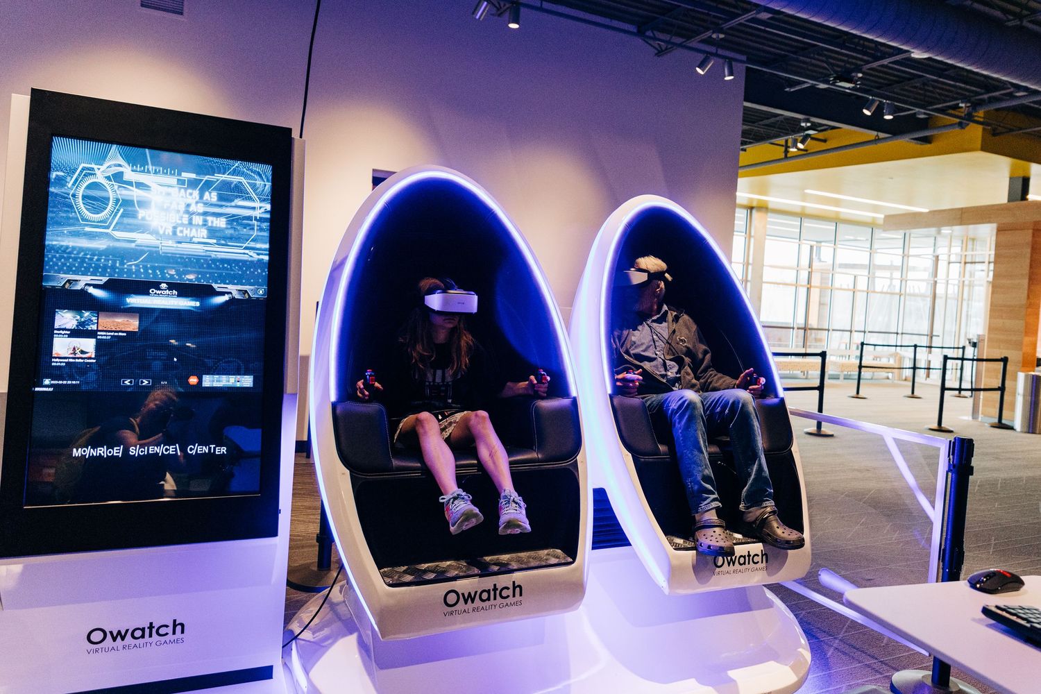 girl and man playing a virtual reality game at Monroe Science Center