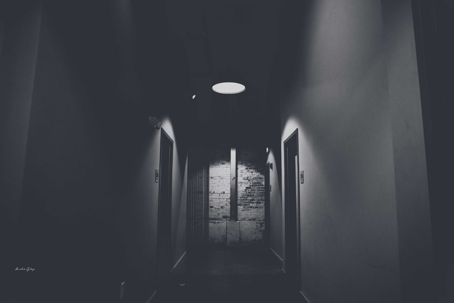 Dark moody corridor with dramatic lighting and symmetrical architecture.