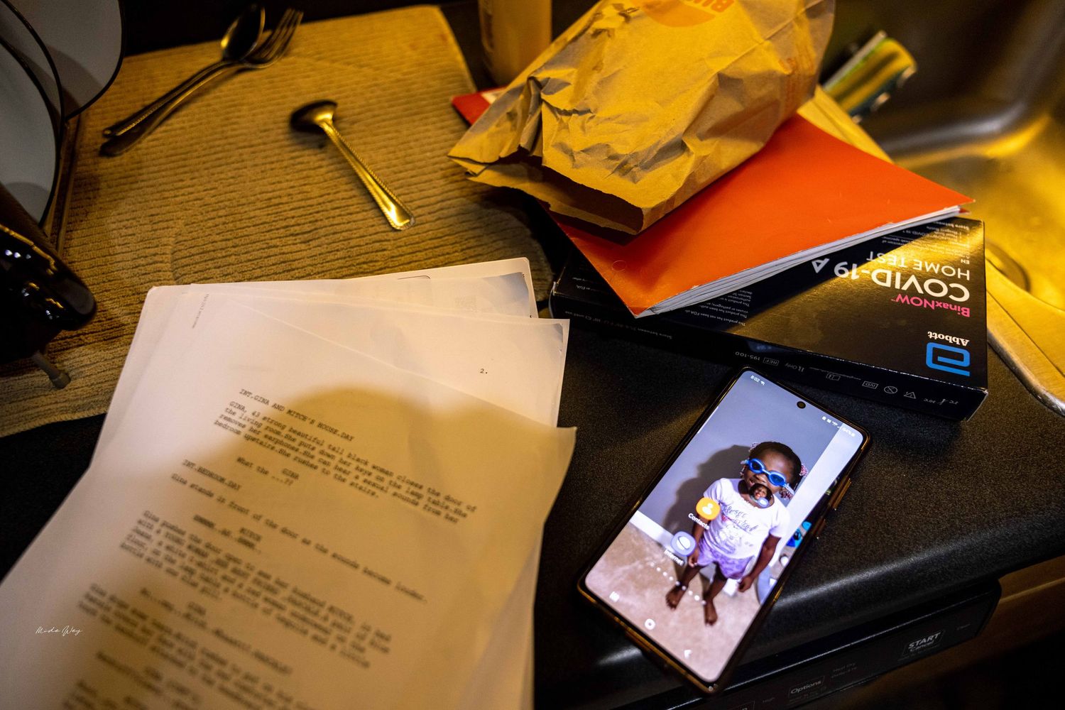Documents and photographs scattered on a desk with office supplies.