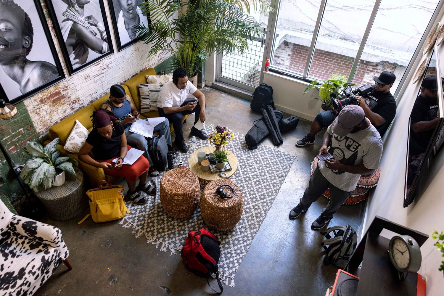 Overhead view of a casual meeting space with yellow chairs and decorative rugs.