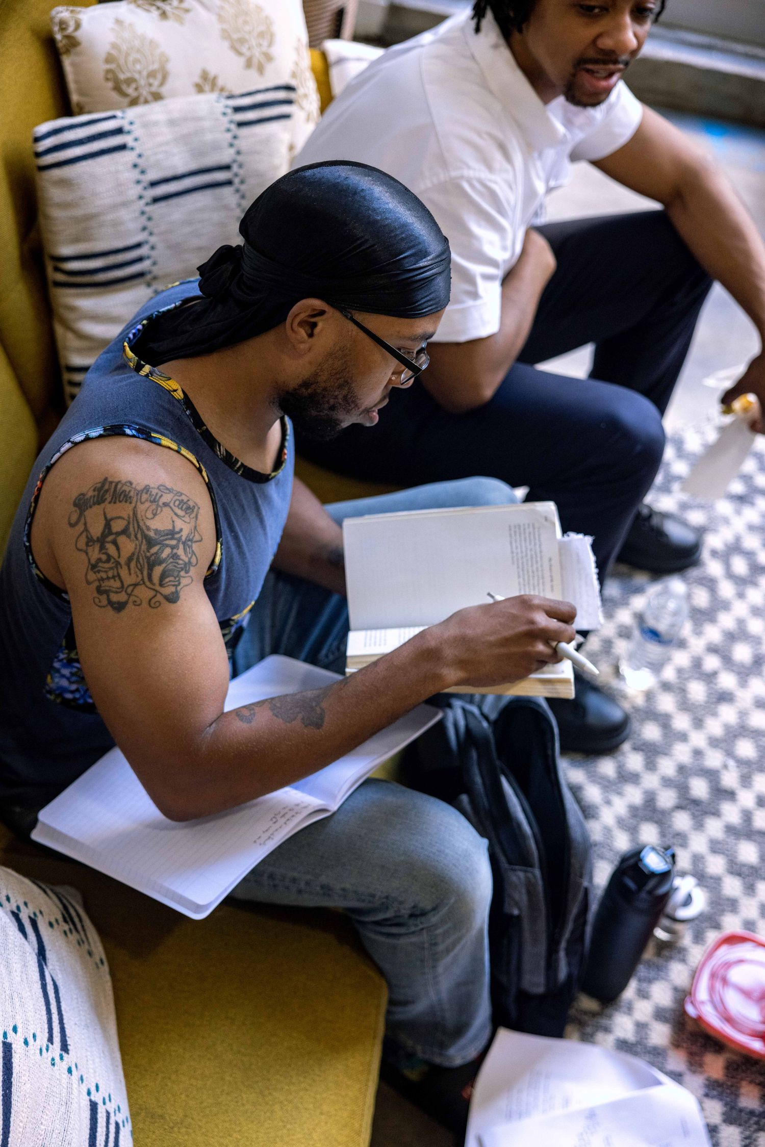 Person in casual attire reviewing documents while seated in an indoor setting.