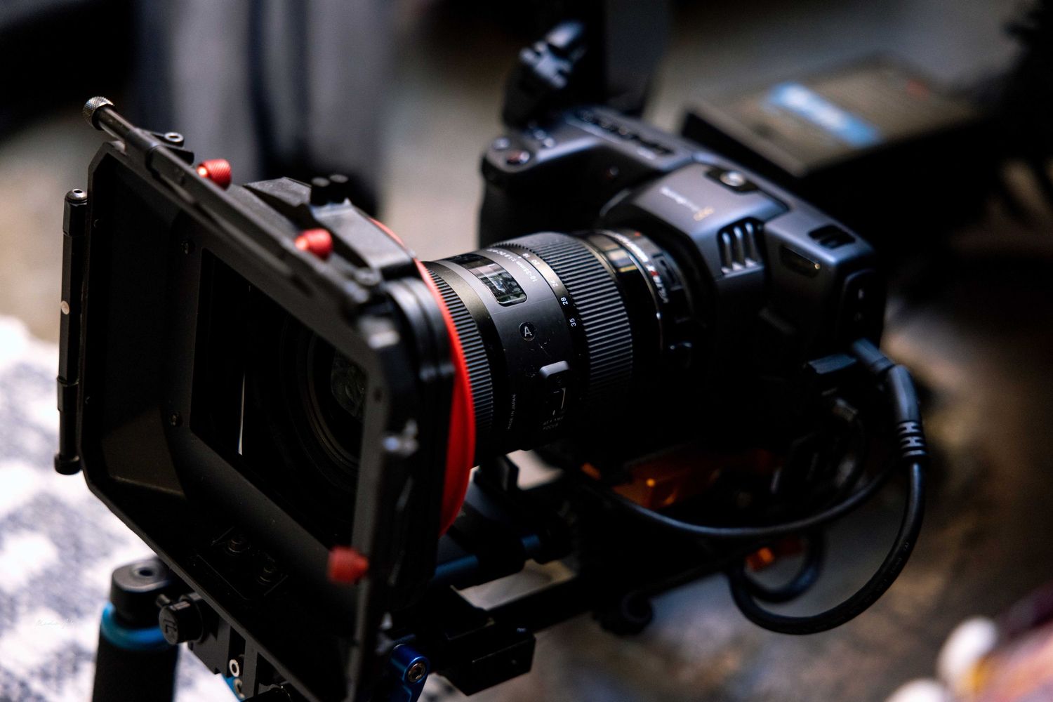 Professional camera equipment and lenses arranged on a dark surface showcasing video production gear.
