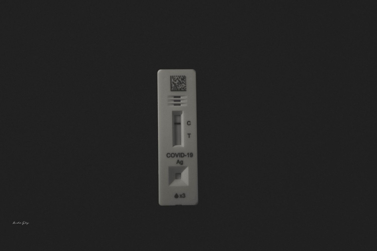 Black and white close-up image of a COVID-19 test strip showing results window.