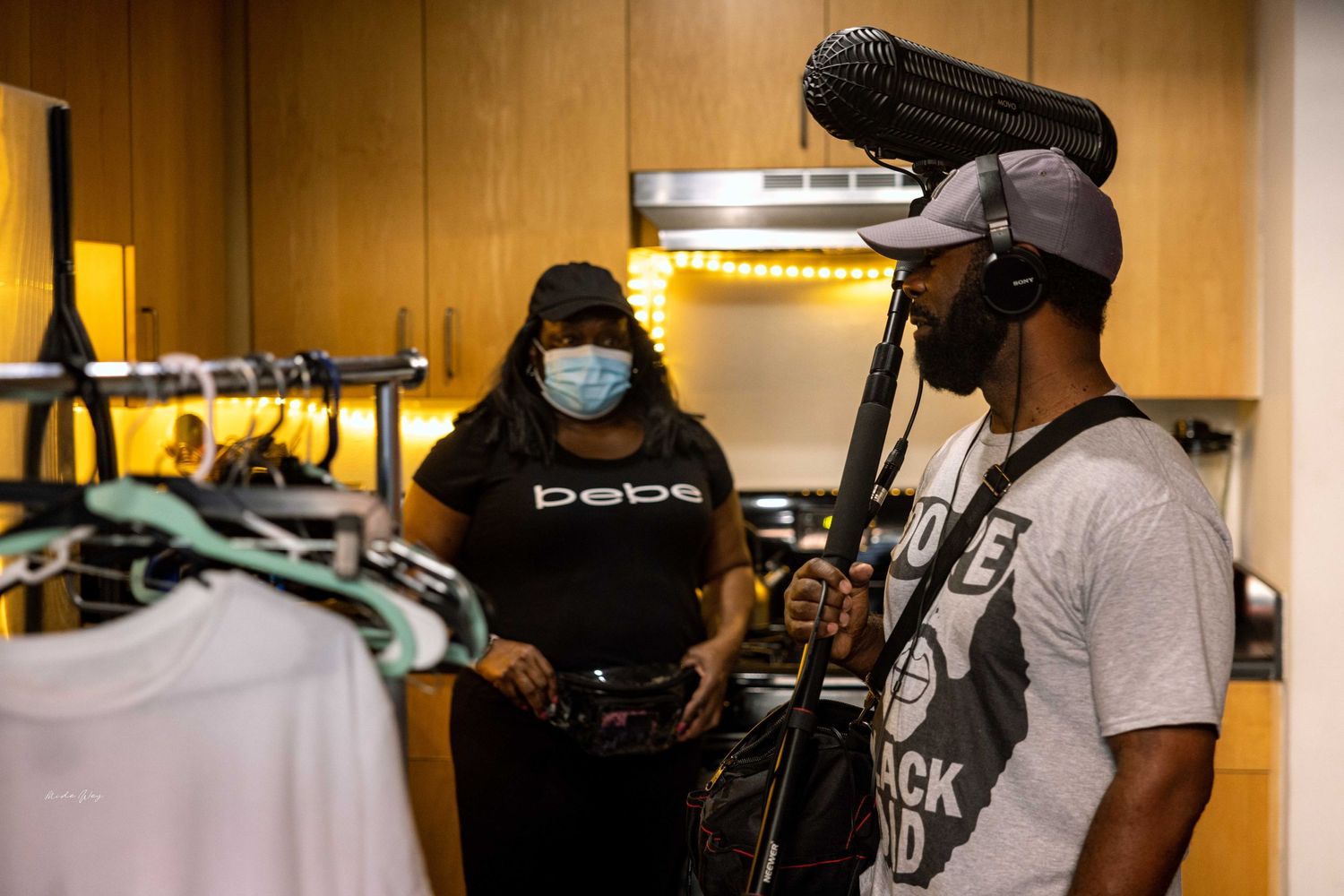 People with recording equipment and face masks in wardrobe area.