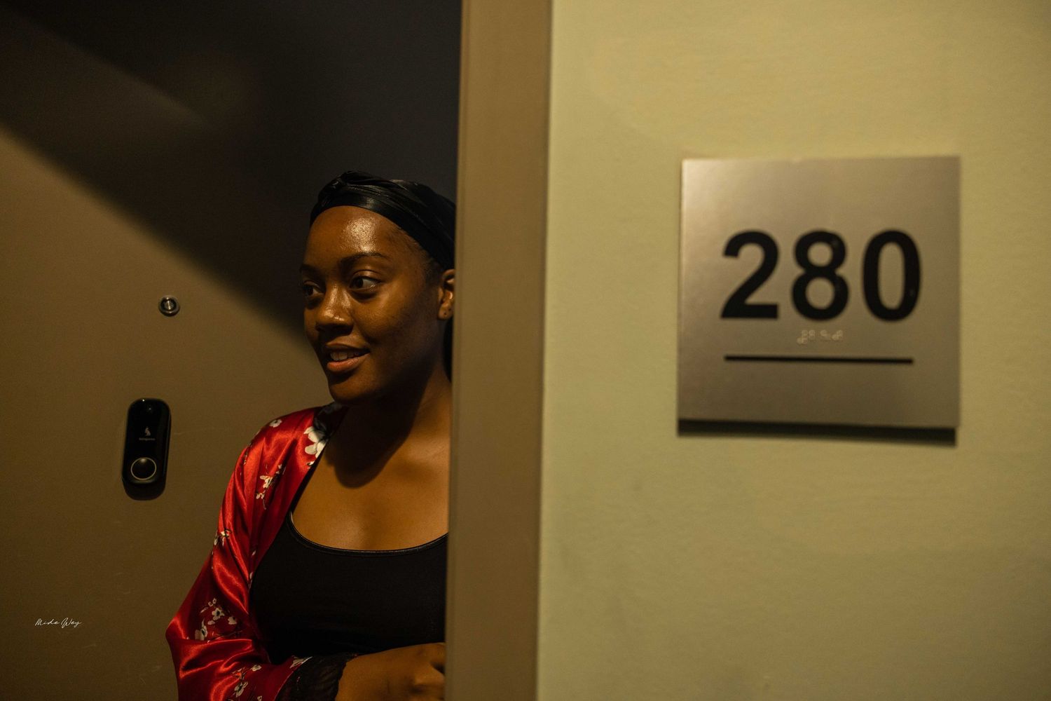A person in red near room number 280 sign in a hallway.