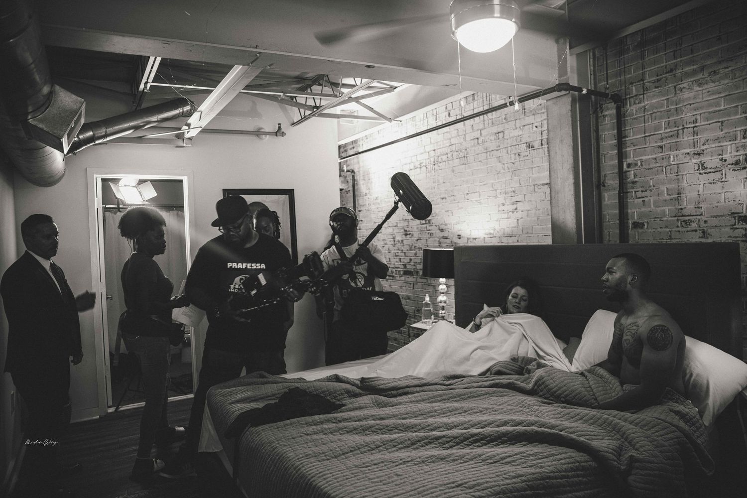 Black and white photo of film production scene in an industrial space.