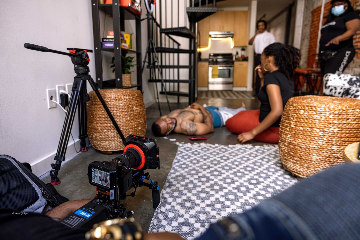 Camera equipment and lighting setup in a brick-walled studio space.