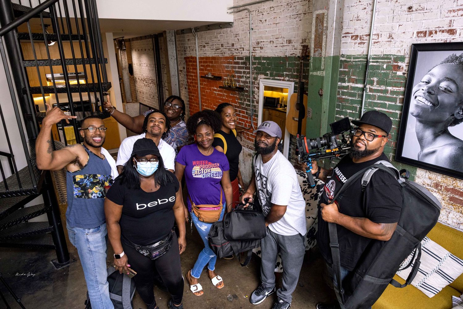 People gathered in an urban setting with exposed brick walls and industrial elements.