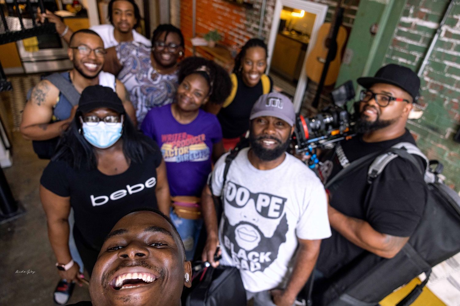 Friends laughing and socializing in an urban industrial-style space with brick walls.
