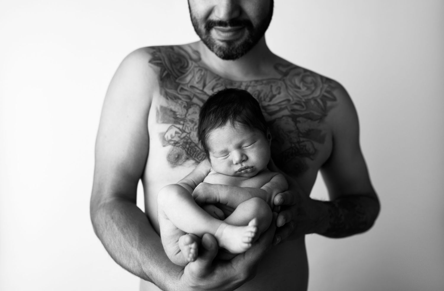 Eden Prairie newborn photographer | black-and-white-image-of-shirtless-dad-holding-newborn-baby