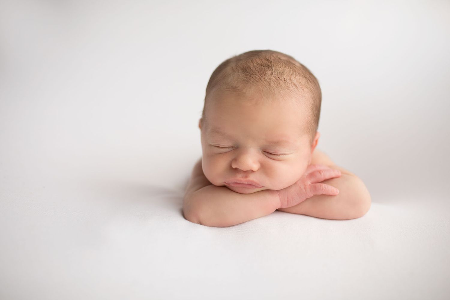 Eden Prairie newborn photographer | baby-laying-facing-forward-on-white-blanket