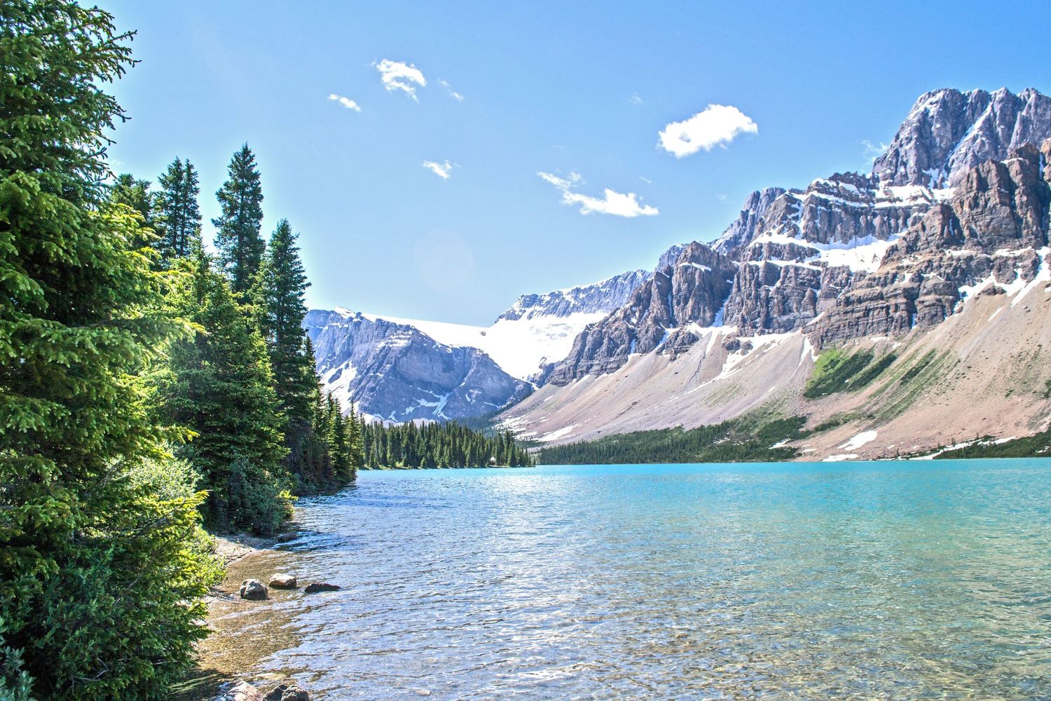 Sunny day on the lake of Banff National Park in Canada. Stunning turquoise waters reflect snowy mountain range.