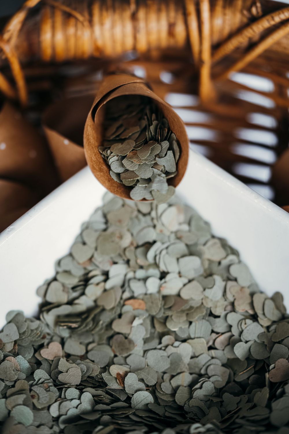 Artistic shot of coins spilling from wooden vessel creating pile of silver currency.