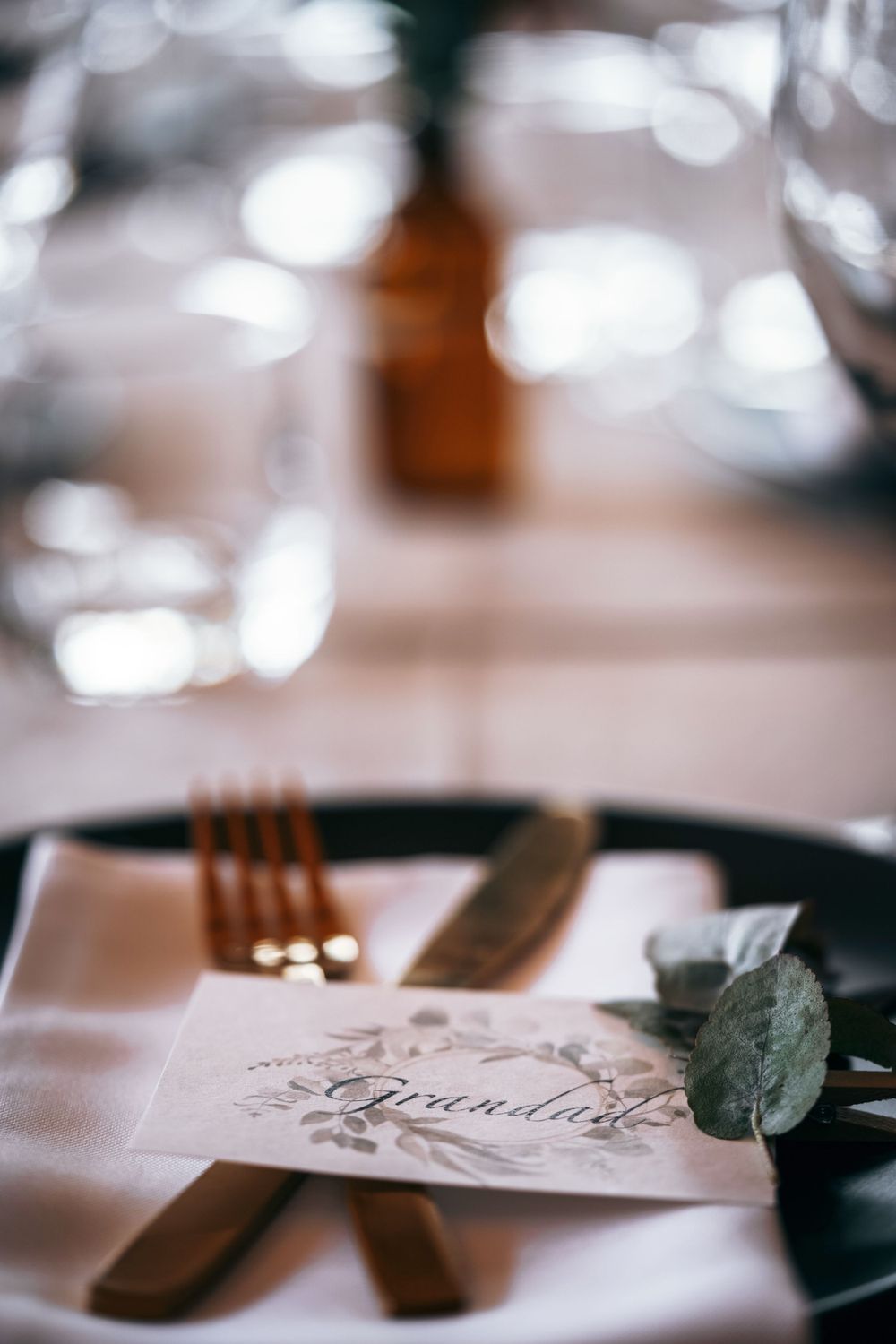 Elegant place setting with vintage silverware and printed menu card on dark plate.