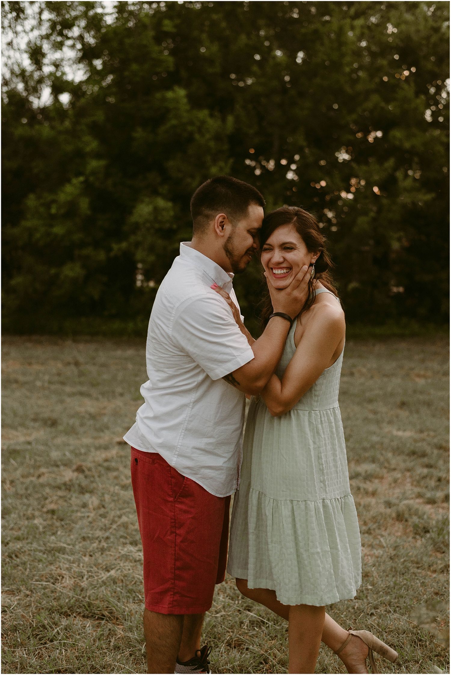 Couple shares joyful moment together outdoors in summer evening light.