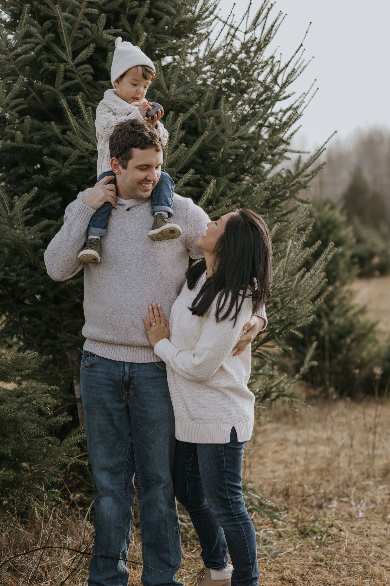 Candid family moment with parents playing with child in winter setting.