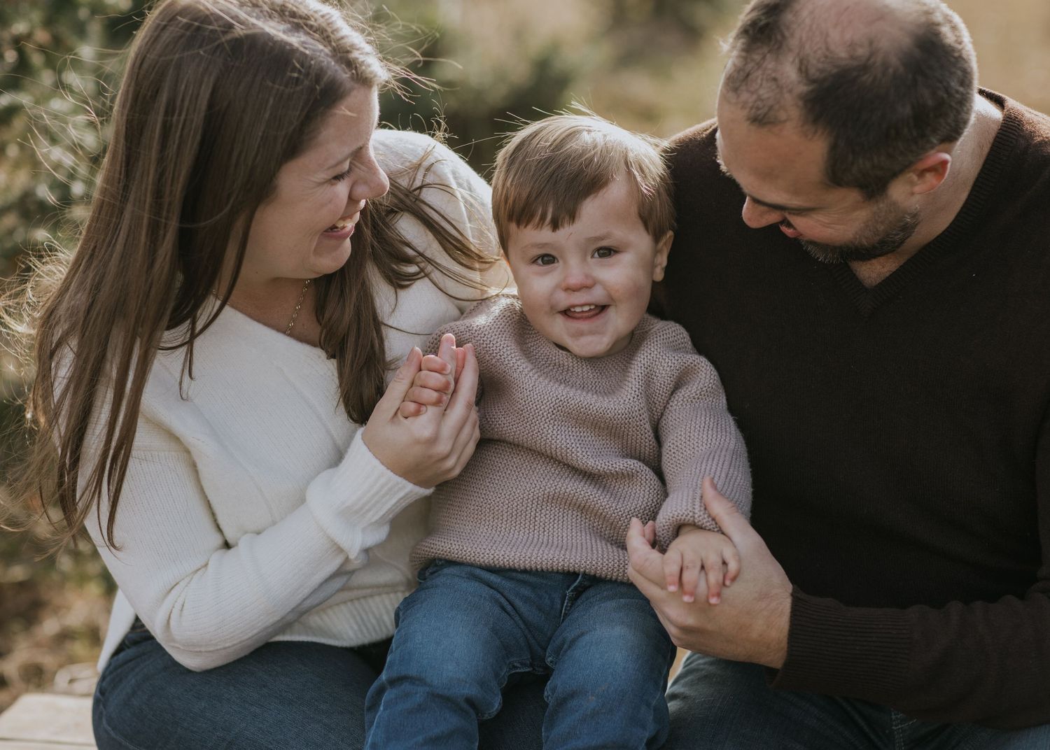 Intimate family moments captured during winter portrait session near pine trees.