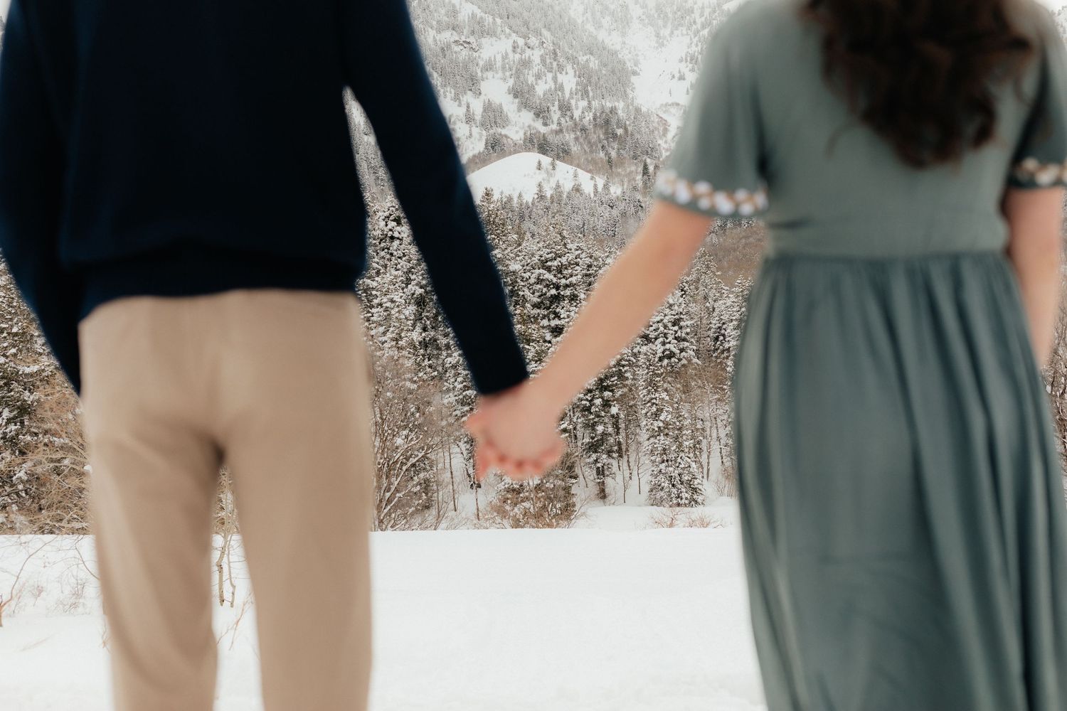 Engaged Couple Holding Hands Out of Focus in Snowy Utah Mountains