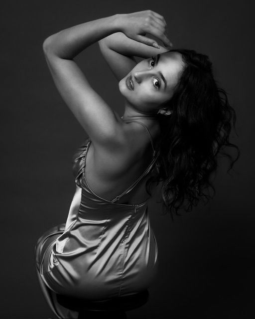 Black and white portrait of woman with curly hair in dramatic pose, studio portrait, North Vancouver