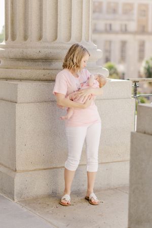 A peaceful moment shared beside a classic stone column in an urban setting.
